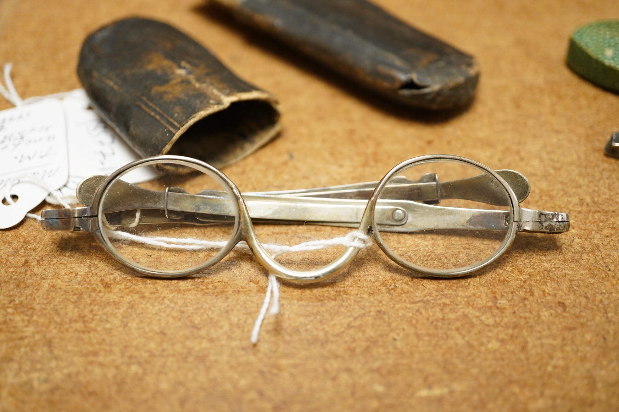 A pair of George III silver framed turn pin spectacles, mm. IH, London 1816, shagreen case, a pair of William IV silver slider spectacles by Thomas Millington, Birmingham, card case (2)